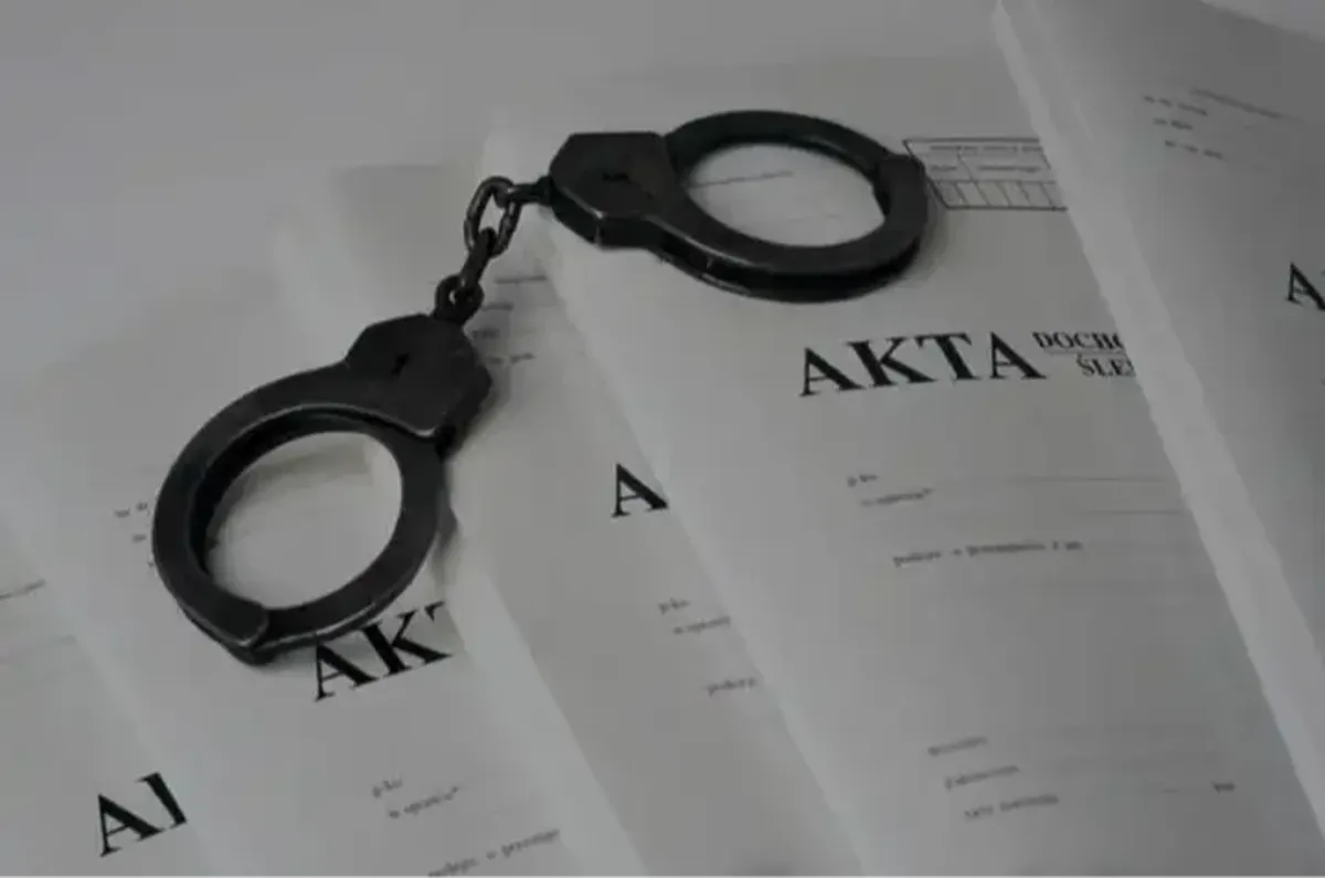 Kajdanki i akta policyjne – zdjęcie ilustracyjne. 61-letni mieszkaniec Mszany Dolnej został aresztowany pod zarzutem znęcania się nad byłą żoną i kierowania gróźb pozbawienia życia. Radio Kraków.