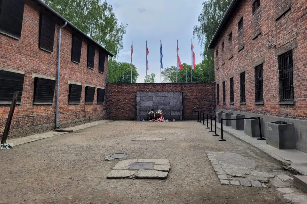 Znicze i kwiaty przed Ścianą Straceń w byłym niemieckim KL Auschwitz