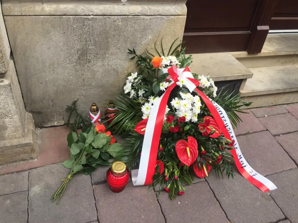 Znicze i kwiaty przed tablicą upamiętniającą Stanisława Pyjasa, w rocznicę jego tragicznej śmierci